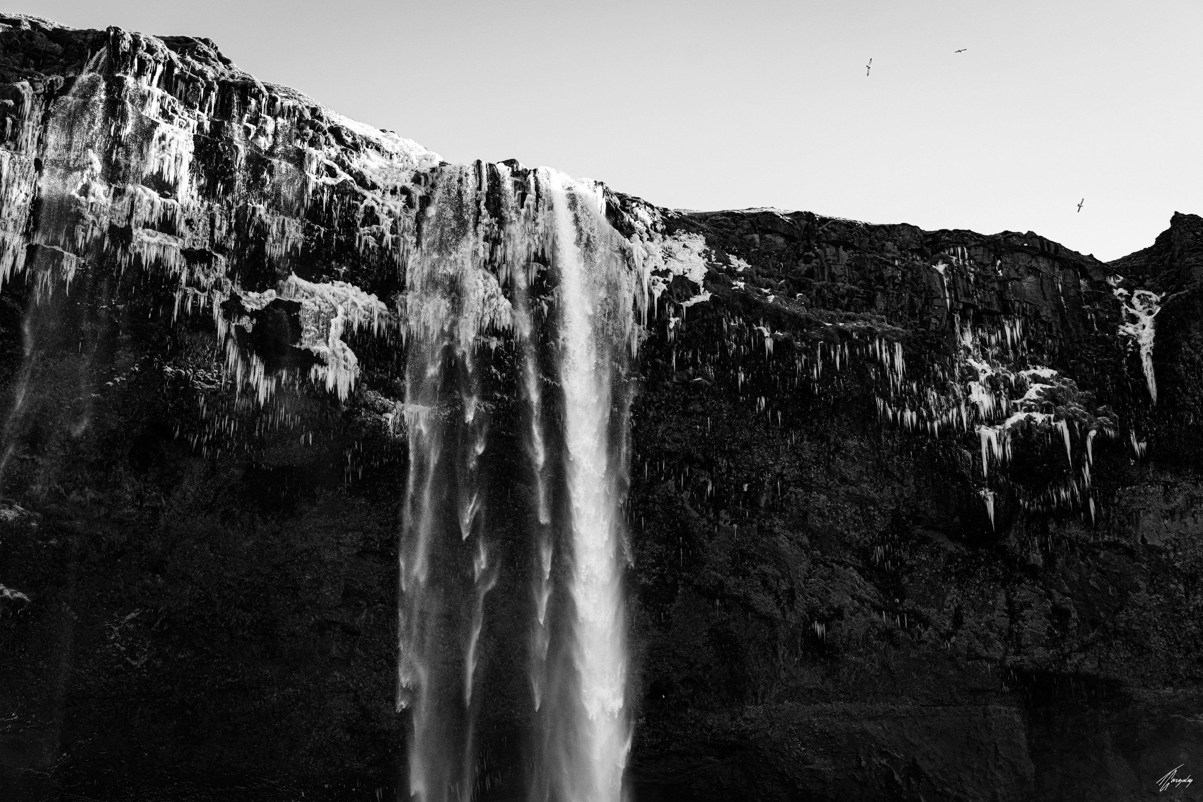 Iceland waterfall with icy cliffs minimalist wall art print frozen textures and flowing water in clean vertical composition